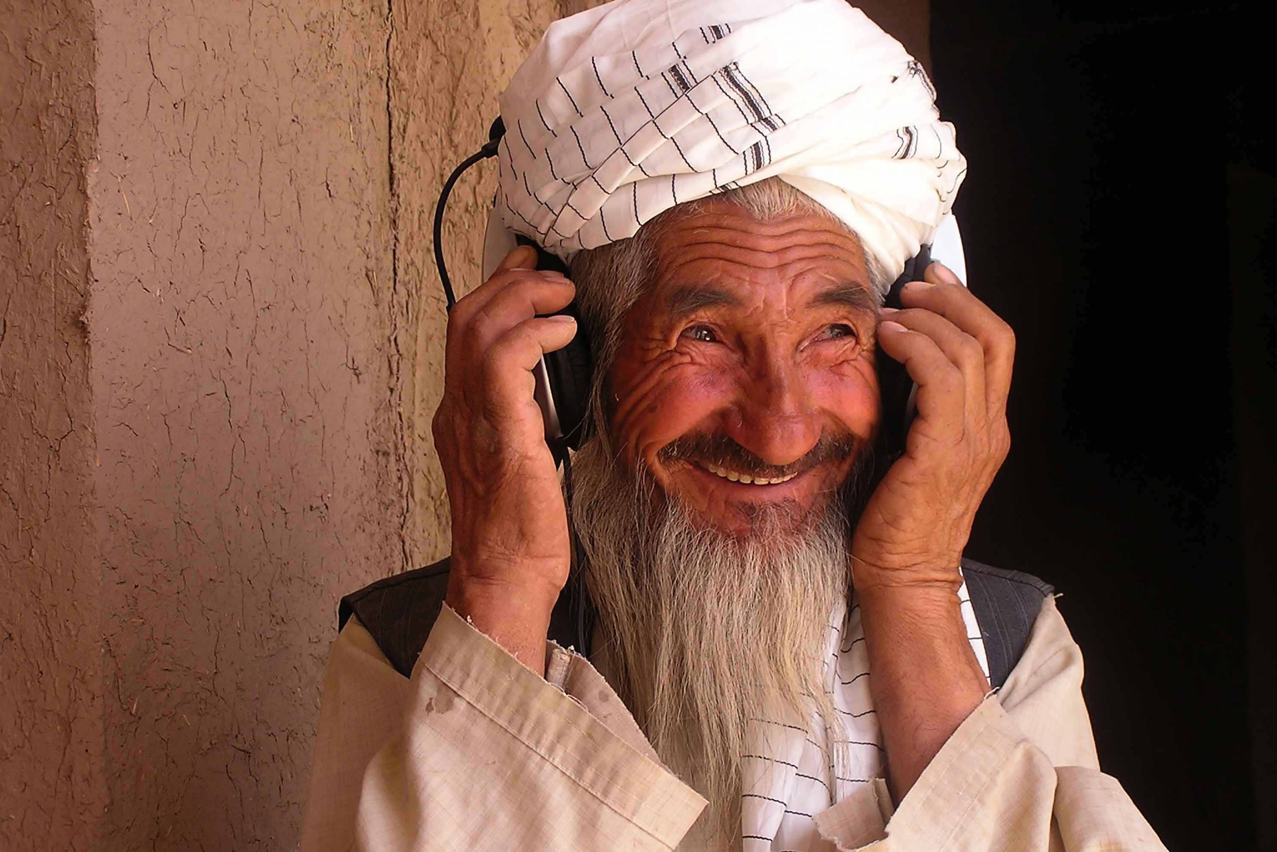 Un contadino della zona rurale ascolta per la prima volta la sua voce in cuffia, Herat, 2006. ©Mariam Alini