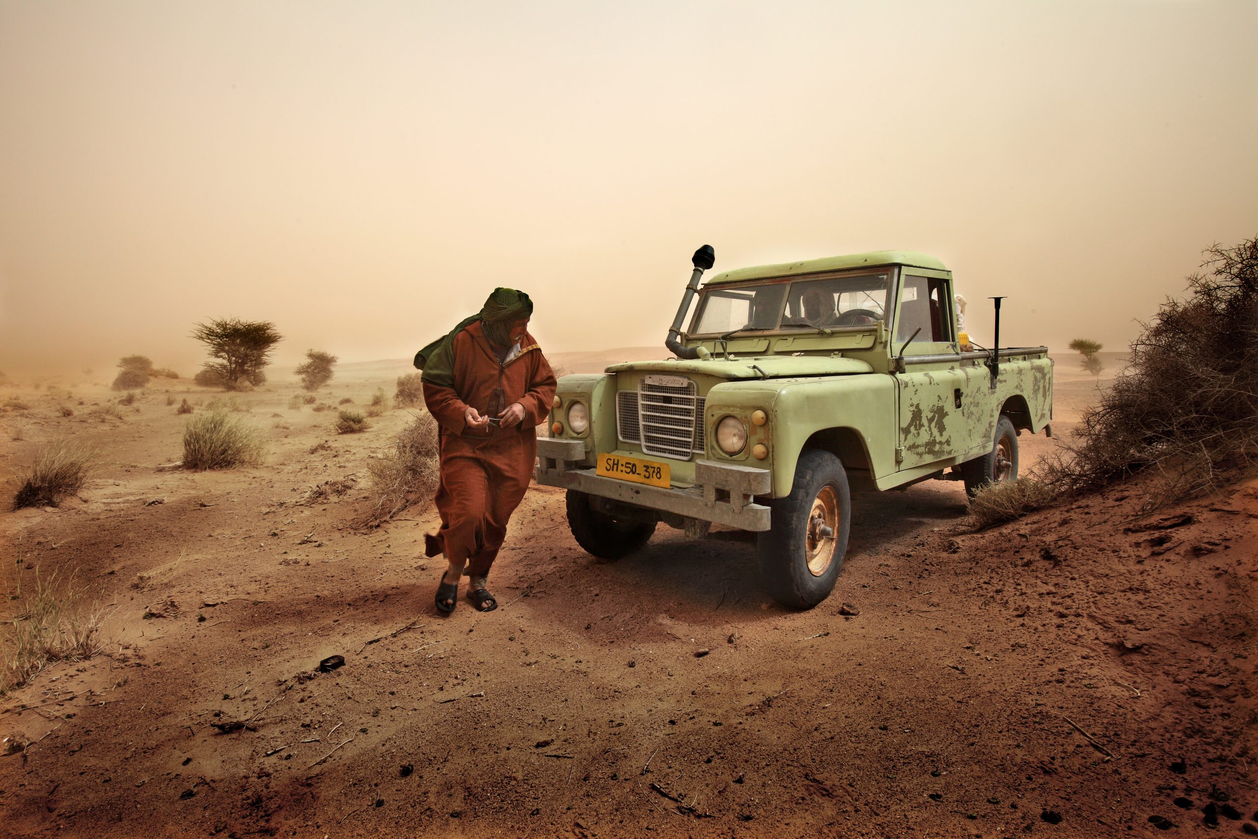 Sahara Occidentale - Un Saharawi con la sua vecchia Land Rover durante una tempesta di sabbia nei territori del Sahara Occidentale liberi dall'invasione marocchina.©Bruno Zanzottera